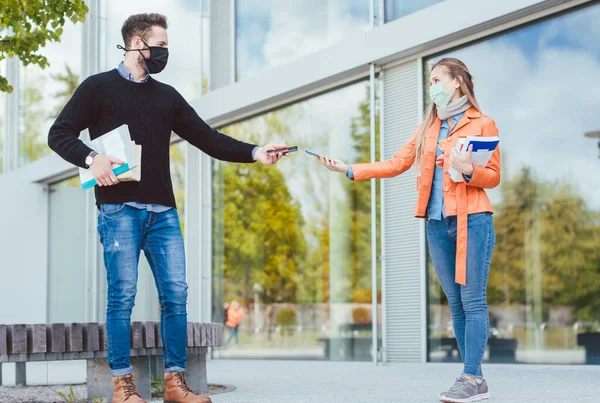 两名学生在使用手机的脑瘤病毒危机中 — 图库照片