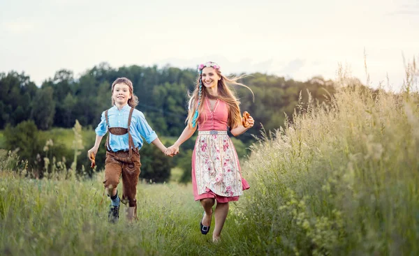 Mãe e filho na Baviera correndo por um caminho — Fotografia de Stock