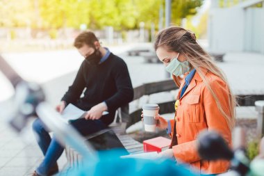 İki üniversite öğrencisi sosyal mesafeyi korurken öğreniyor