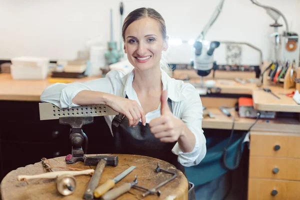 Portret van een goudsmid in haar werkplaats staande temidden van gereedschap — Stockfoto