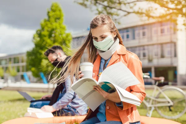 Kobieta student na kampusie studenckim uczy się nosić maskę twarzy — Zdjęcie stockowe