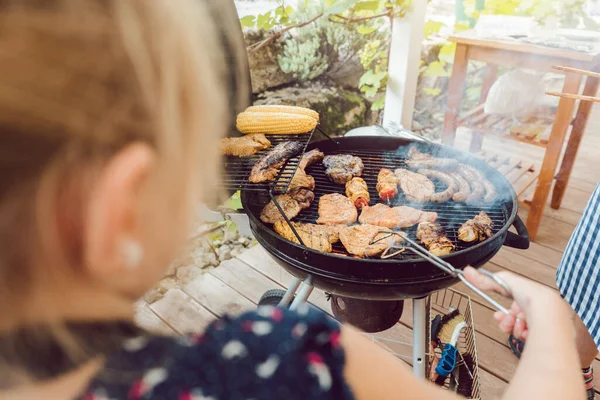 Liten jente som griller kjøttet for BBQ – stockfoto