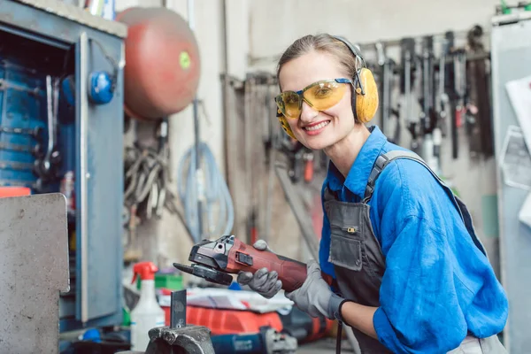 Kvinnlig mekaniker som arbetar med diskkvarn — Stockfoto