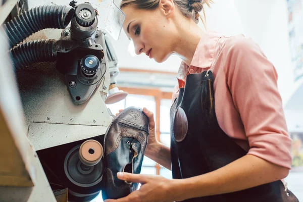 Schustersfrau arbeitet in ihrer Schuhmacherwerkstatt an Maschine — Stockfoto