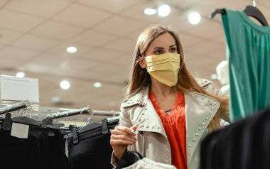 Moda mağazasında maske takan bir kadın.
