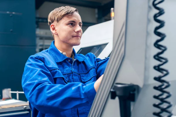 Junger Arbeiter programmiert Drehmaschine in Fabrik — Stockfoto