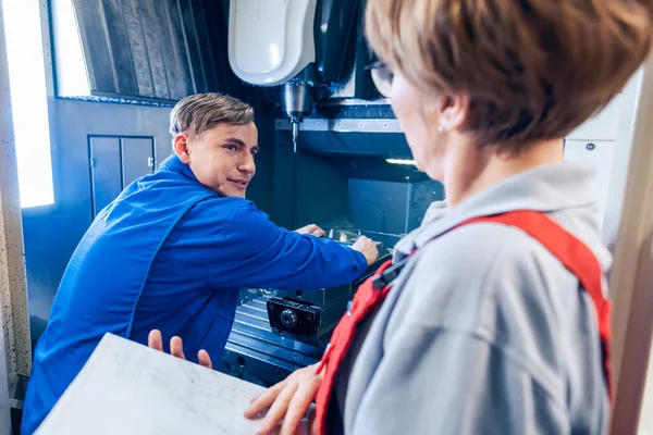Supervisor beobachtet jungen Arbeiter beim Umstellen der Drehmaschine — Stockfoto