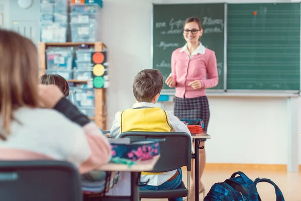 Alunos em classe ansiosos para responder a uma pergunta para seu professor — Fotografia de Stock