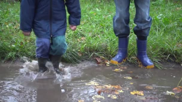 Dos chicos saltando en charco fangoso, cámara lenta 250 fps — Vídeo de stock