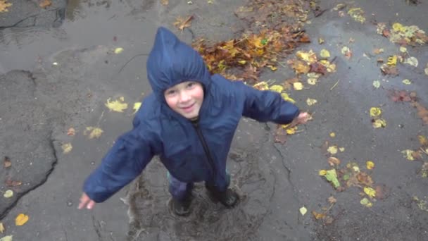 Kleiner Junge springt in schlammige Pfütze, Zeitlupe 250 fps — Stockvideo