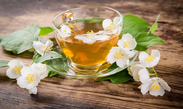 Herbal tea with jasmine flowers on rustic table — Stock Photo, Image