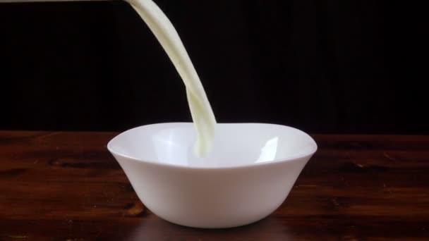 Kukoricapehely és tej esik le a tálat, lassú mozgás — Stock videók
