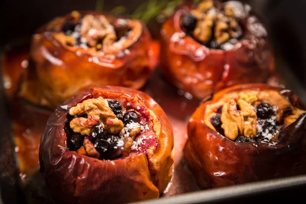 Four backed apples with nuts and berries — Stock Photo, Image