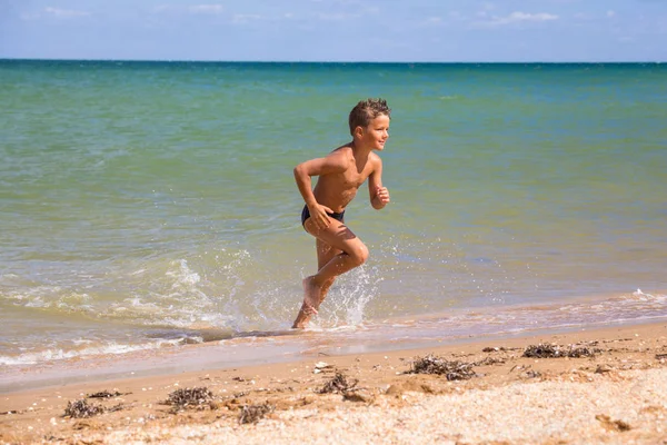 Pojke som körs från havet på stranden — Stockfoto