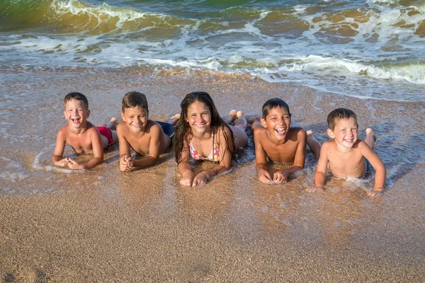 Fem unger på stranda. – stockfoto