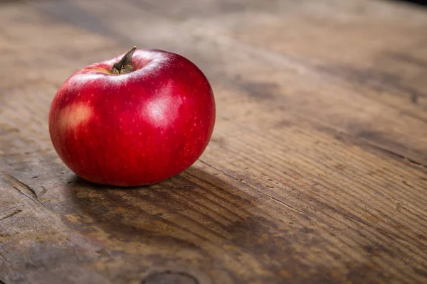 Manzana roja sobre mesa de madera oscura —  Fotos de Stock