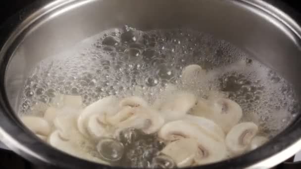 Boiling water with mushrooms in metal pan, slow motion — Stock Video