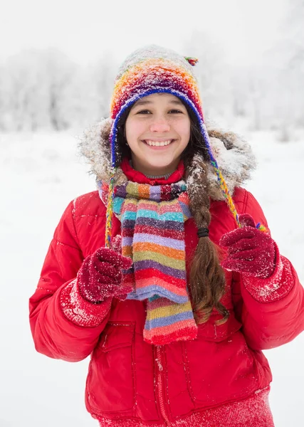 Girl standing in colorful warm clothes on snowy landscape — Stock Photo, Image