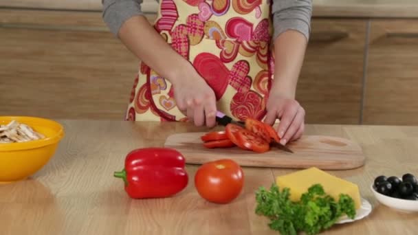 Bedårande ung flicka Skär tomaterna i köket — Stockvideo