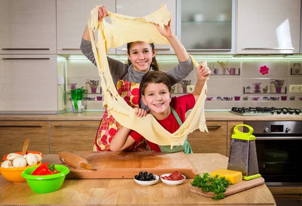 Двое забавных детишек смешивают тесто, делают пиццу — стоковое фото