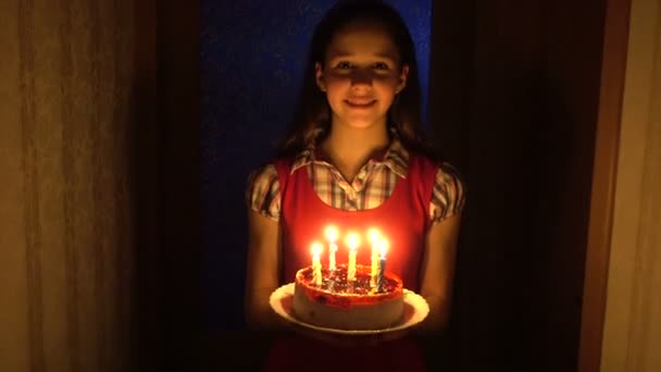 Flickan bär födelsedagstårta med ljus i mörkret — Stockvideo