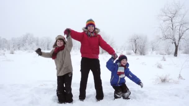 Трое детей прыгают вместе по зимнему пейзажу, замедленная съемка — стоковое видео