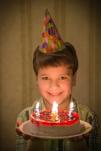 Garçon souriant tenant gâteau d'anniversaire dans les mains — Photo