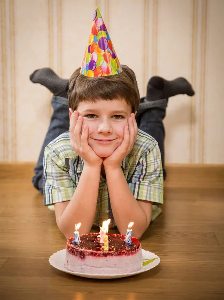 Улыбающийся мальчик с тортом на полу — стоковое фото