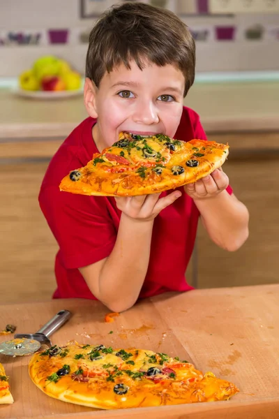 Divertente ragazzo mangiare il grande pezzo di pizza — Foto Stock