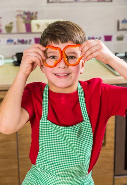 Rolig bedårande pojke med skivad paprika på ögon — Stockfoto