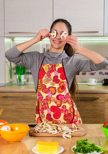 Hauska tyttö sieniä viipaleita silmissä tehdä pizzaa — kuvapankkivalokuva