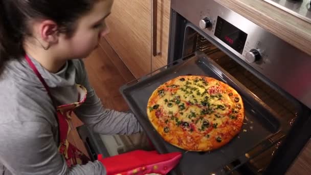 Girl pull out hot pizza from oven — Stock Video