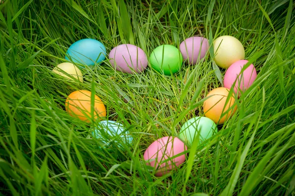 Achtergrond met kleurrijke Pasen eieren op weide in hart vorm — Stockfoto