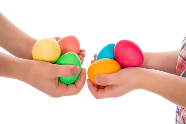 Pilha de ovos de páscoa coloridos em duas mãos de criança — Fotografia de Stock