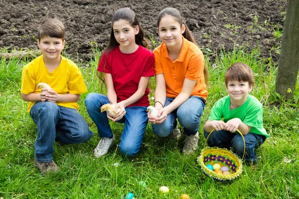 Enfants souriants à l'herbe verte tenant un peu de poulets, Pâques co — Photo