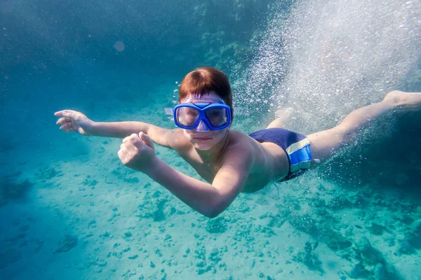 Jongen in zwemmen masker diepe duik in de rode zee in de buurt van coral reef — Stockfoto