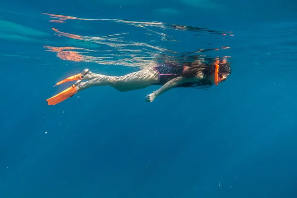 Meisje in zwemmen masker en flippers duiken in de rode zee — Stockfoto