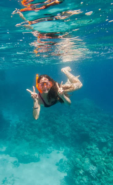 Meisje in het zwemmen masker duik onderwater in de buurt van coral reef — Stockfoto