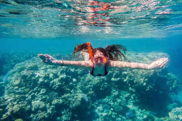 Meisje in zwemmen masker duiken in de rode zee in de buurt van coral reef — Stockfoto