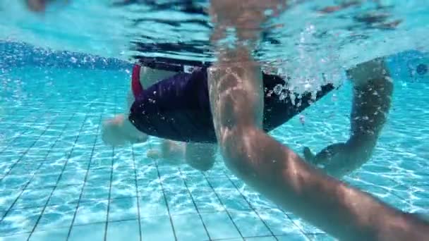 Niño pequeño nadar en la piscina, disparar bajo el agua — Vídeo de stock