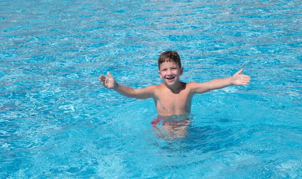 Mały chłopiec, łapanie piłki w basenie — Zdjęcie stockowe