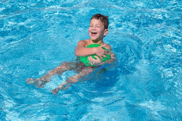 Little boy playing with ball in the pool — Stock Photo, Image