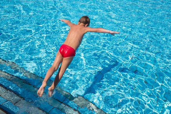 Мальчик прыгает в бассейн — стоковое фото
