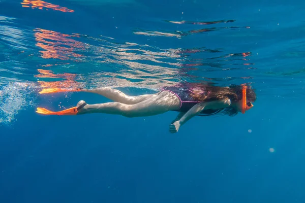 Mädchen mit orangefarbener Schwimmmaske und Schwimmflossen tauchen in die Tiefsee — Stockfoto