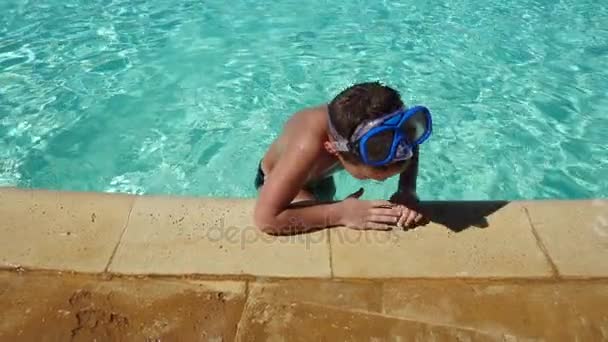 Menino sorridente na máscara de natação sair da piscina azul — Vídeo de Stock