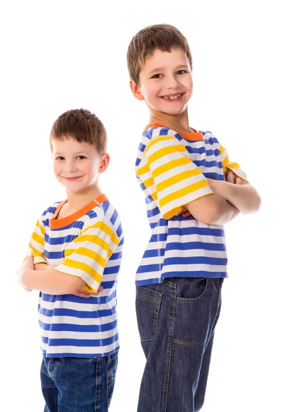 Dua anak laki-laki tersenyum berdiri bersama-sama di latar belakang putih — Stok Foto