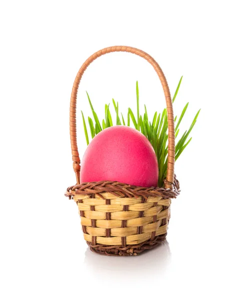 Huevo de Pascua rosa en la pequeña canasta con hierba verde —  Fotos de Stock