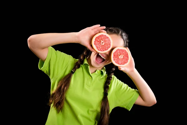 Opgewonden grappig meisje met gesneden grapefruit op ogen — Stockfoto