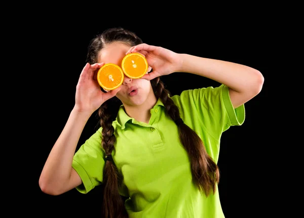 Menina engraçada surpreso com laranja fatiada nos olhos — Fotografia de Stock