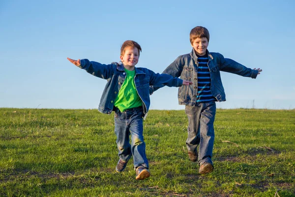 Two brothers running together on meadow — Stock Photo, Image